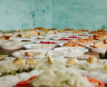 Various snacks and fruits displayed on plates over a rustic wooden table.