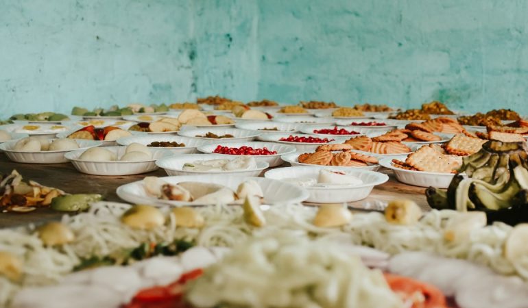 Various snacks and fruits displayed on plates over a rustic wooden table.