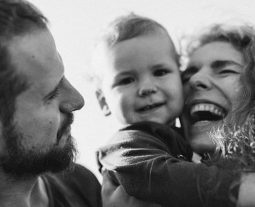 A happy family enjoying a heartfelt moment together in a black-and-white setting.